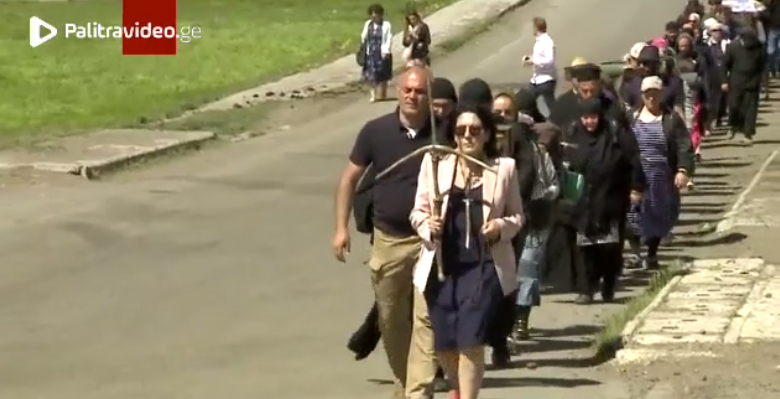 სალომე ზურაბიშვილი გულზე დაკიდებული წმინდა ნინოს ჯვრითა და ხელში ვაზის ჯვრით