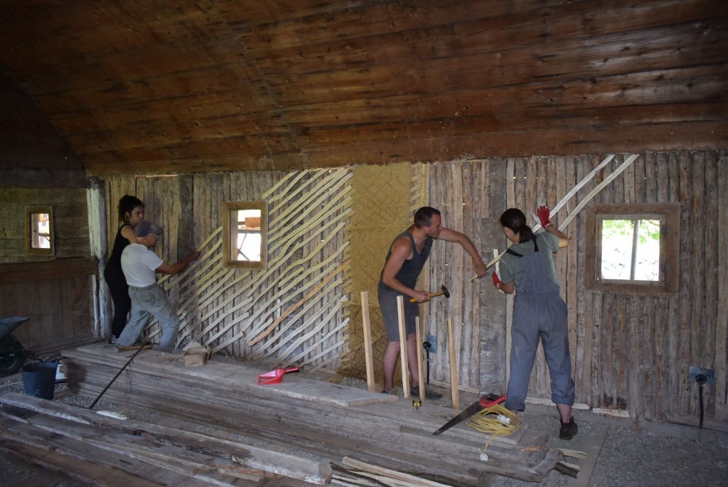 Studenții de la Arhitectură deprind tehnica tencuirii cu pământ și paie la restaurarea unei biserici din Timiș