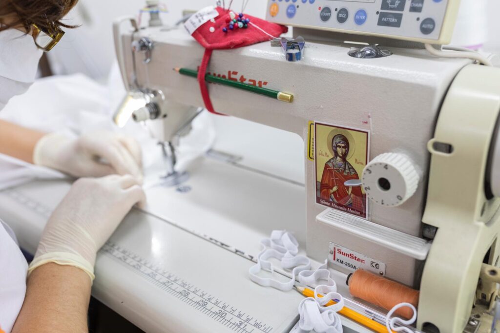 Atelierele Arhiepiscopiei Bucureștilor produc combinezoane din poliester pentru voluntari