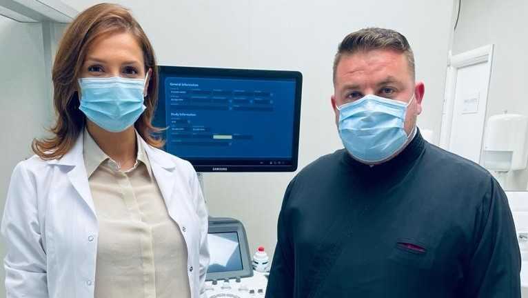 Un medic și un preot își dau mâna pentru a oferi servicii gratuite de sănătate pentru femei