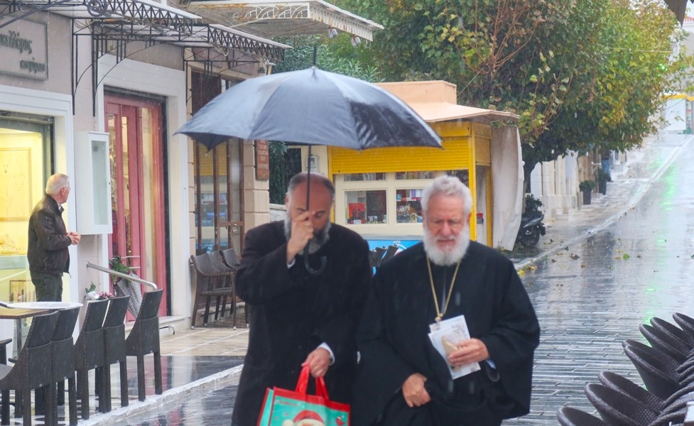 Υπό καταρρακτώδη βροχή ο Μητροπολίτης Σύρου χαιρέτησε τους καταστηματάρχες της Χώρας Άνδρου (ΦΩΤΟ)